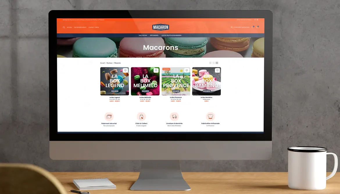 Imac sur un bureau en bois avec une tasse de café affichant le site web e-commerce de la boulangerie Macaron à Fontaine de Vaucluse